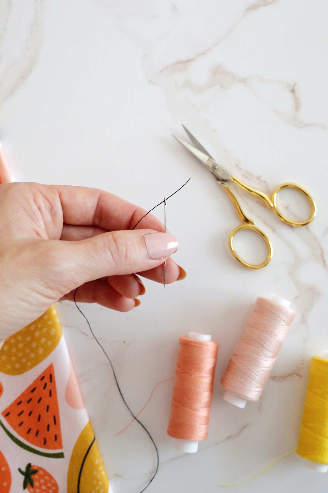 hand holding a threaded needle